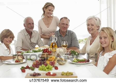 Happy family sitting at a table View Large Photo Image Stock Photo - Happy family sitting at a table. Fotosearch