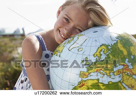 Stock Image - Happy girl with a globe. Fotosearch