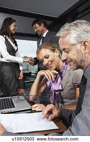 Stock Image - In a business meeting. Fotosearch