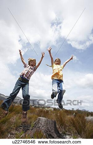 Stock Photograph - Kids jumping in the fields. Fotosearch