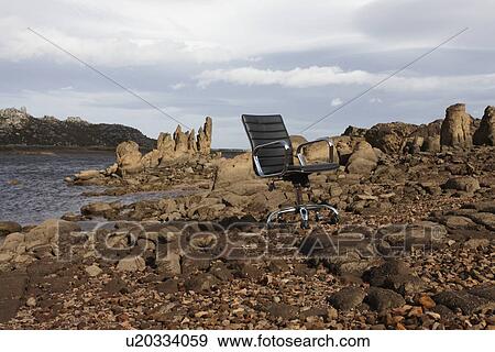 Lonely chair on the rocks View Large Photo Image Stock Photo - Lonely chair on the rocks. Fotosearch