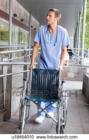 Male nurse with a wheelchair View Large Photo Image Stock Image - Male nurse with a wheelchair. Fotosearch