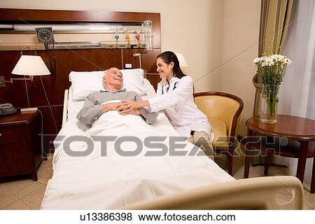 Stock Photo - Man in a hospital being comforted by a doctor. Fotosearch