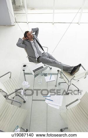 Stock Image - Man relaxing at work. Fotosearch