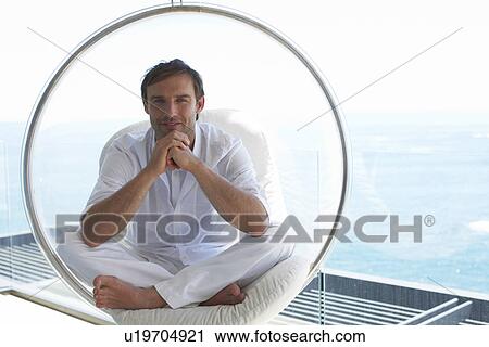 Stock Image - Man sitting on a design chair. Fotosearch