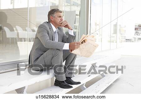Mature businessman reading a newspaper View Large Photo Image Picture - Mature businessman reading a newspaper. Fotosearch