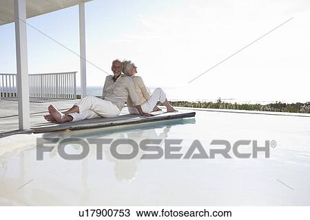 Stock Image - Mature couple at a pool. Fotosearch