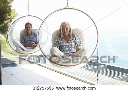 Mature couple sitting on chairs View Large Photo Image Stock Photography - Mature couple sitting on chairs. Fotosearch