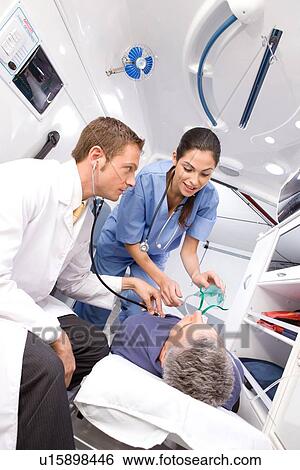 Stock Photograph - Medical professionals and patient in ambulance. Fotosearch