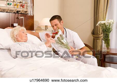 Stock Image - Offering flowers to a patient. Fotosearch