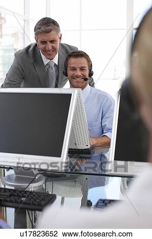 Stock Image - Older and younger businessmen at work. Fotosearch