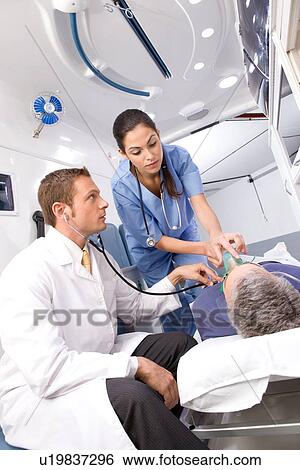 Stock Photograph - Paramedics with a patient. Fotosearch