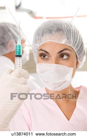 Stock Image - Physician holding a syringe. Fotosearch