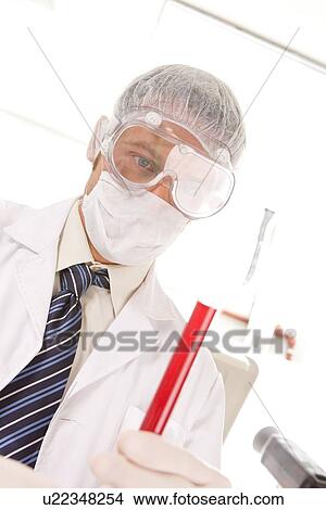 Picture - Scientist holding a tube. Fotosearch
