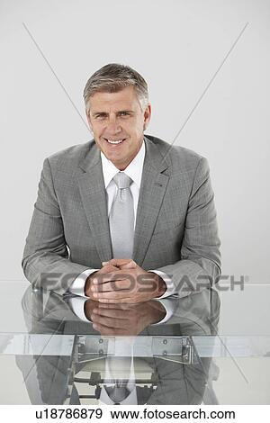 Smiling executive in his office View Large Photo Image Stock Photo - Smiling executive in his office. Fotosearch