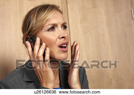Stressed woman on a phone View Large Photo Image Stock Photograph - Stressed woman on a phone. Fotosearch