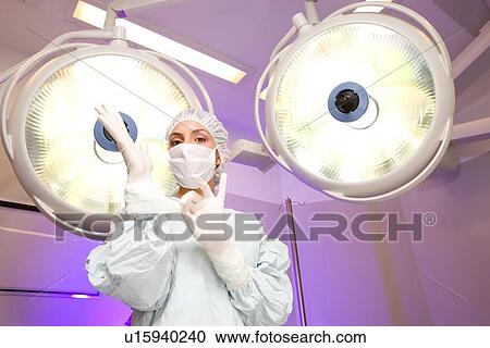 Stock Image - Surgeon preparing for operation. Fotosearch