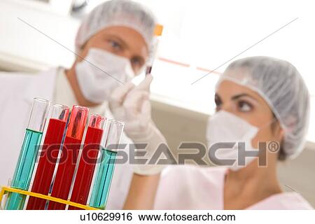 Tubes with scientists in the background View Large Photo Image Stock Photograph - Tubes with scientists in the background. Fotosearch