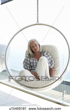 Woman sitting on a design chair View Large Photo Image Stock Image - Woman sitting on a design chair. Fotosearch