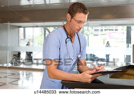 Stock Image - Young doctor writing. Fotosearch
