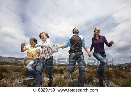 Stock Photo - Young family in the meadow. Fotosearch