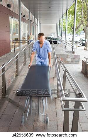 Stock Photo - Young nurse with a stretcher. Fotosearch