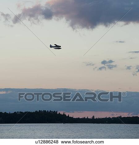 Stock Photo - Airplane flying over Lake of the Woods, Ontario. Fotosearch