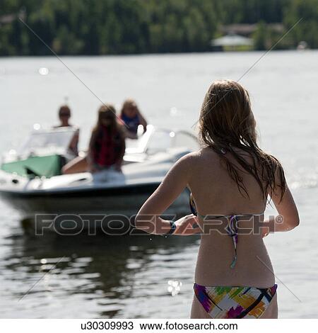Stock Image - Back view of a girl in a bikini at Lake of the Woods, Ontario. Fotosearch