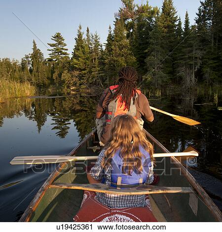 Back view of people rowing a canoe at Lake of the Woods, Ontario View Large Photo Image Stock Image - Back view of people rowing a canoe at Lake of the Woods, Ontario. Fotosearch
