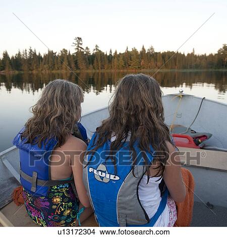 Back view of two girls wearing life jackets at Lake of the Woods, Ontario View Large Photo Image Picture - Back view of two girls wearing life jackets at Lake of the Woods, Ontario. Fotosearch