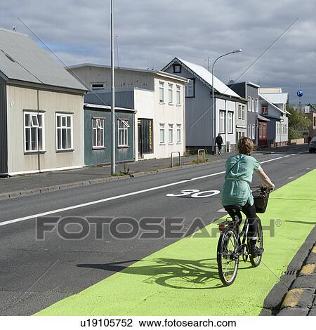 Bicycle rider on roadside bike path next to dwellings View Large Photo Image Stock Image - Bicycle rider on roadside bike path next to dwellings. Fotosearch