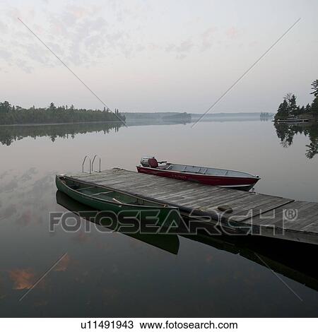 Stock Image - Boat at a dock in Lake of the Woods, Ontario. Fotosearch