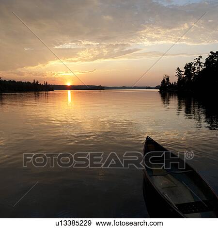 Canoe floating on the water at Lake of the Woods, Ontario View Large Photo Image Stock Photo - Canoe floating on the water at Lake of the Woods, Ontario. Fotosearch