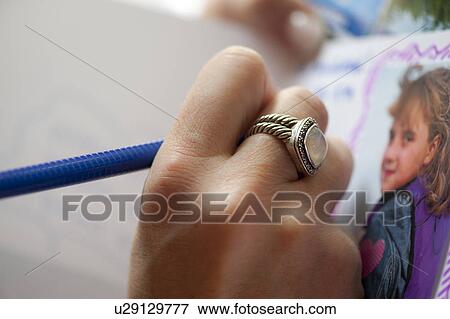 Close up of a ring on a hand drawing a picture View Large Photo Image Stock Photo - Close up of a ring on a hand drawing a picture. Fotosearch