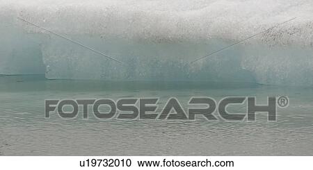 Closeup delicate melting iceberg at water's edge View Large Photo Image Stock Image - Closeup delicate melting iceberg at water's edge. Fotosearch