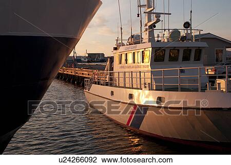 Stock Image - Coast Guard vessel moored at Reykjavik harbour, reflections in the ocean water. Fotosearch