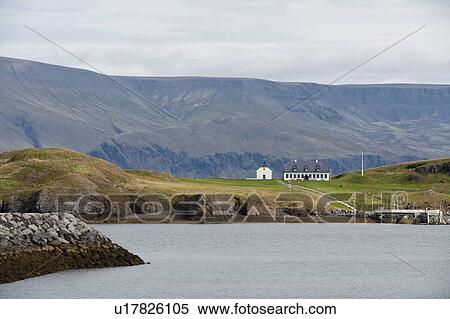 Stock Photography - Coastline with wharf, building, and mountains. Fotosearch