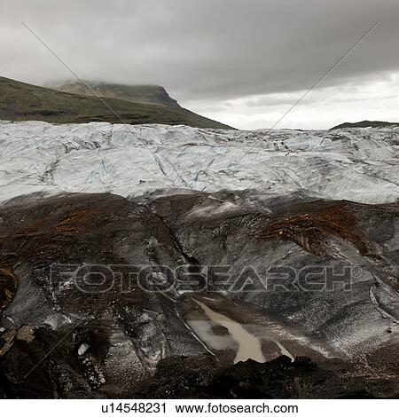 Dirty glacier melting into lake at shoreline, below misty mountain valley View Large Photo Image Stock Image - Dirty glacier melting into lake at shoreline, below misty mountain valley. Fotosearch