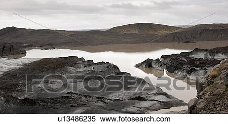Stock Photography - Dirty, muddy melting glaciers next to glacial lake. Fotosearch