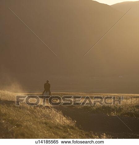Stock Photography - Evening horseback ride through countryside, sepia tones. Fotosearch