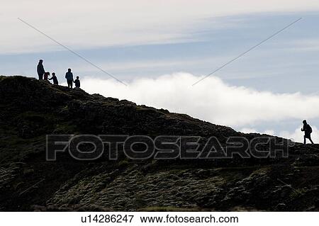 Stock Photo - Family group climbing a rocky rough incline, in silhouette. Fotosearch