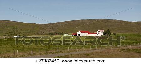 Stock Image - Farm buildings on hillside with horses and pasture, cloudless. Fotosearch