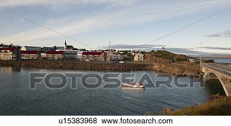 Fishing boat in river, next to town and bridge View Large Photo Image Stock Photo - Fishing boat in river, next to town and bridge. Fotosearch