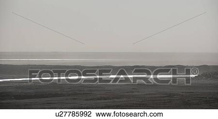 Stock Image - Foggy ocean shoreline looking out upon the horizon. Fotosearch