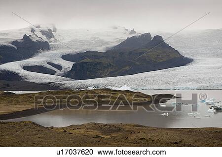Stock Image - Frozen blue icebergs in a glacial lake. Fotosearch