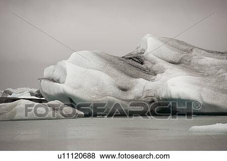 Frozen blue icebergs in a glacial lake View Large Photo Image Stock Photo - Frozen blue icebergs in a glacial lake. Fotosearch