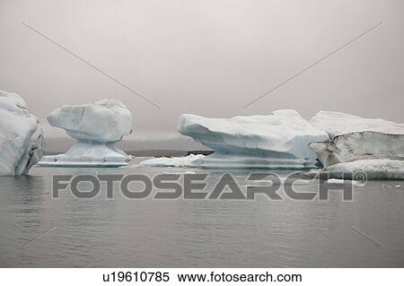Stock Photography - Frozen blue icebergs in a glacial lake. Fotosearch
