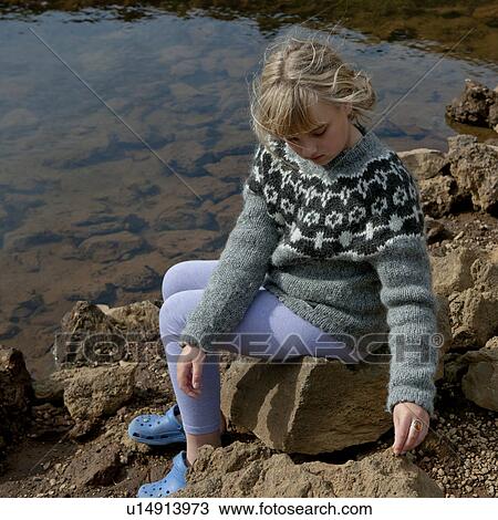 Girl in sweater sitting on rocks by lakeshore View Large Photo Image Stock Image - Girl in sweater sitting on rocks by lakeshore. Fotosearch