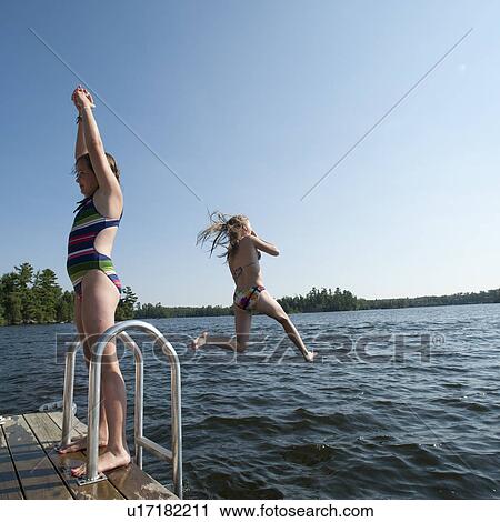 Girl jumping into the water at Lake of the Woods, Ontario View Large Photo Image Stock Image - Girl jumping into the water at Lake of the Woods, Ontario. Fotosearch