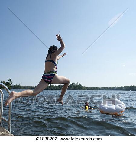 Girl jumping into the water at Lake of the Woods, Ontario View Large Photo Image Stock Image - Girl jumping into the water at Lake of the Woods, Ontario. Fotosearch